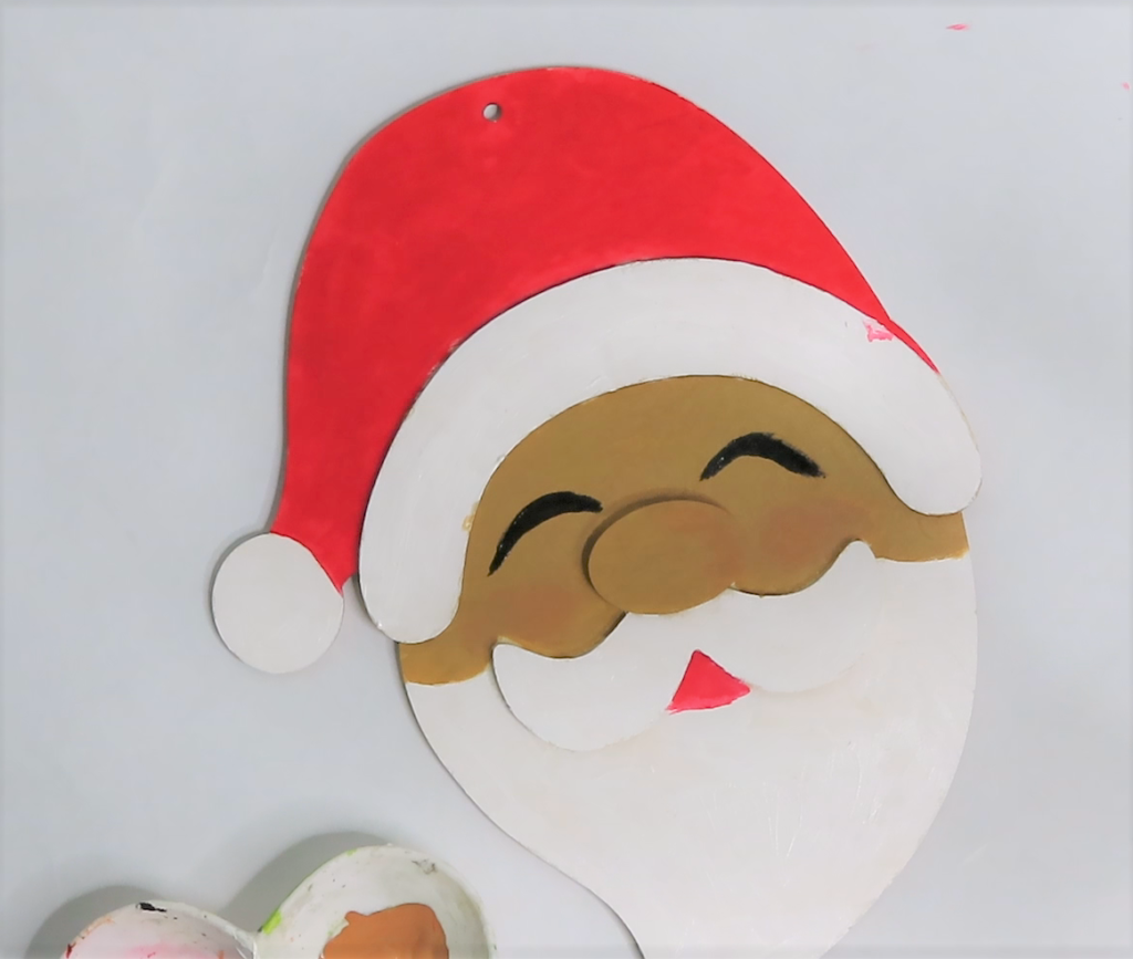 Paint Santa's squinty eyes with black acrylic craft paint | How to Turn a Dollar Tree Santa into a Masterpiece