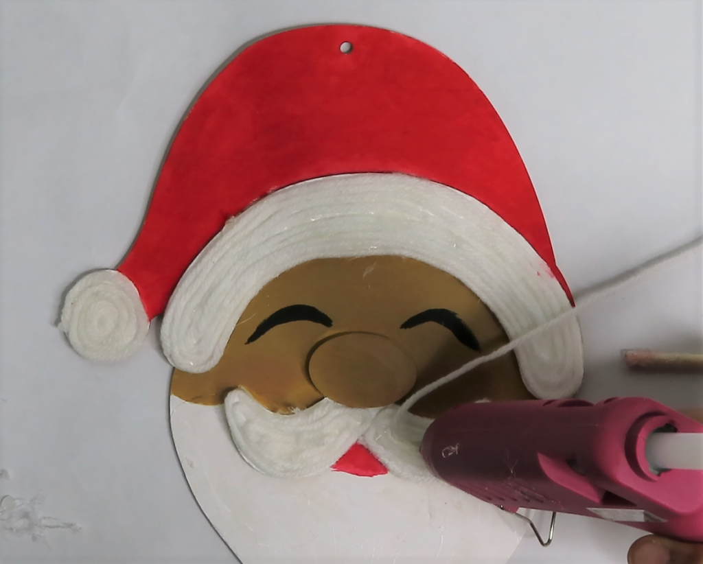 Add yarn to Santa's mustache | How to Turn a Dollar Tree Santa Head into a Masterpiece