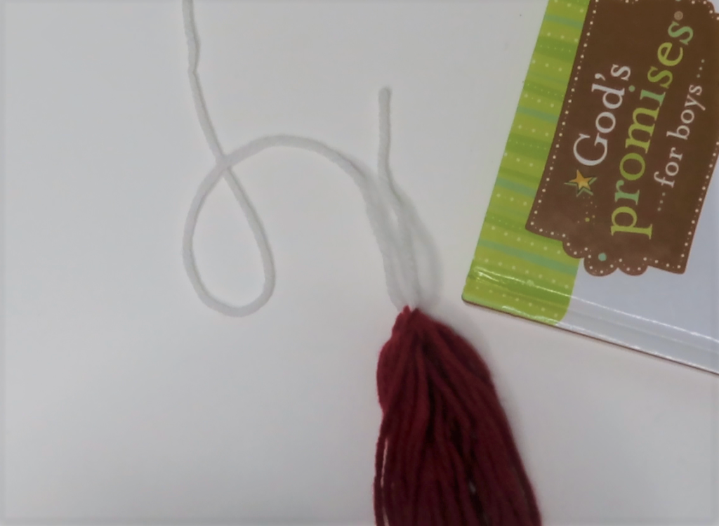 Attach the tassel to a small piece of string and tie a knot | Make Your Own Tassel Garland in No Time