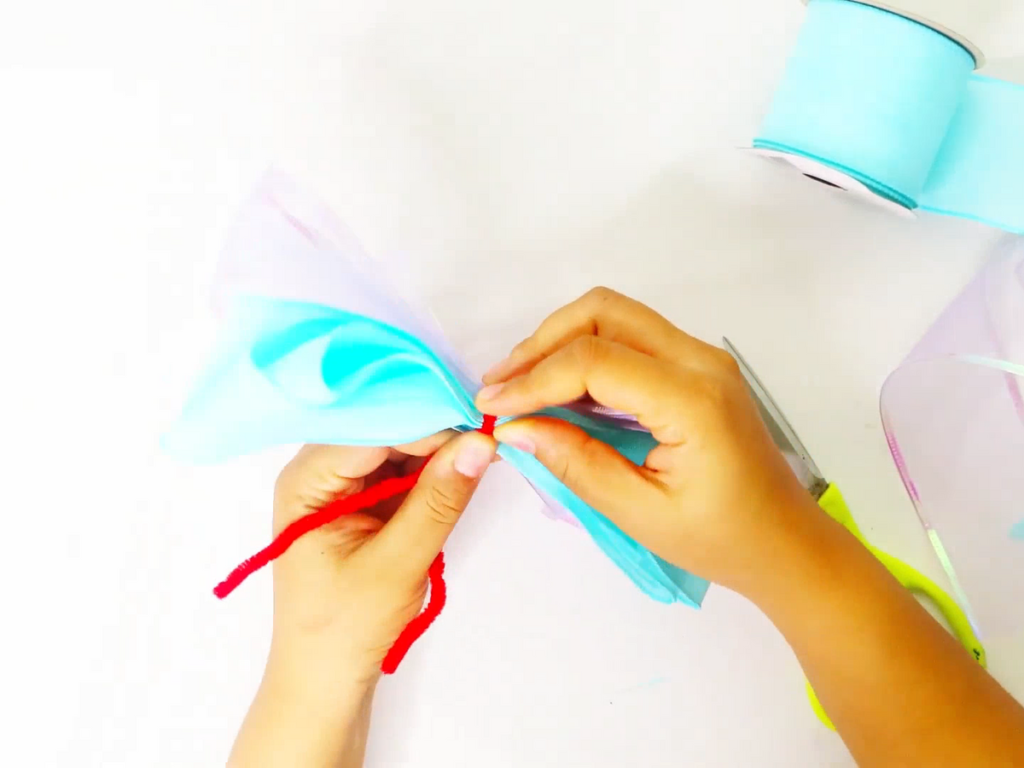 Put the two ribbons on top of each other and connect them using pipe cleaner