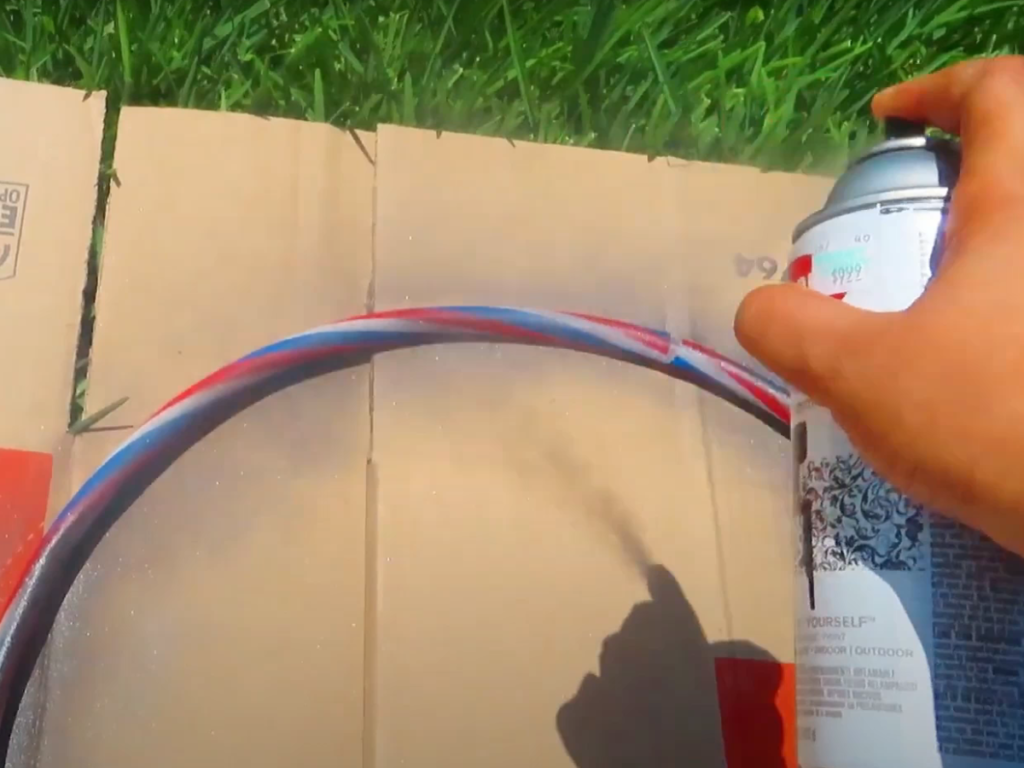 Spray the hula hoop with black spray paint with primer