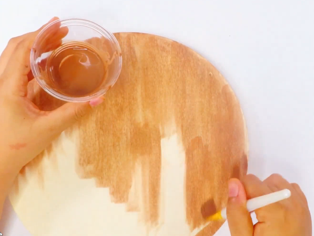 Paint the circle with watered down brown paint to create the look of stain