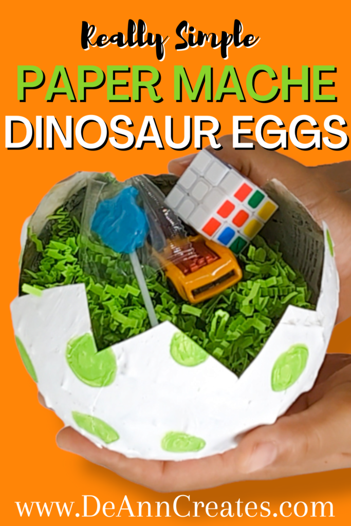 This image shows a Pinterest pin entitled "Really Simple Paper Mache Dinosaur Eggs." The image on the Pin shows two hands holding a white paper mache egg with green spots. Inside the egg is lime green filler crinkle paper and several party favors.