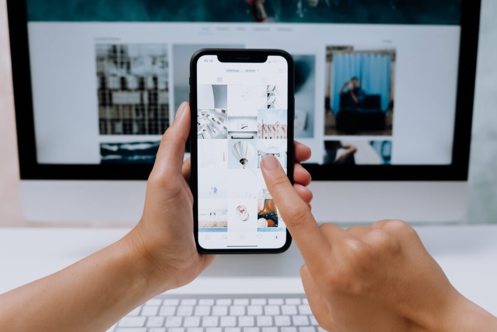 The image shows a pair of hands holding a smart phone while creating a vision board | The Ultimate Craft App Guide for Crafters of All Ages | Photo by Cottonbro Studio
