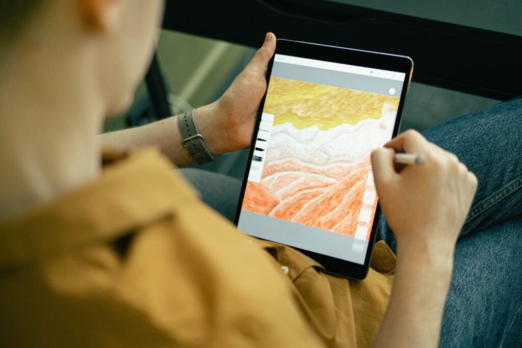 This image shows a guy drawing digital art on his tablet | The Ultimate Craft App Guide for Crafters of All Ages | Photo by Ivan Samkov