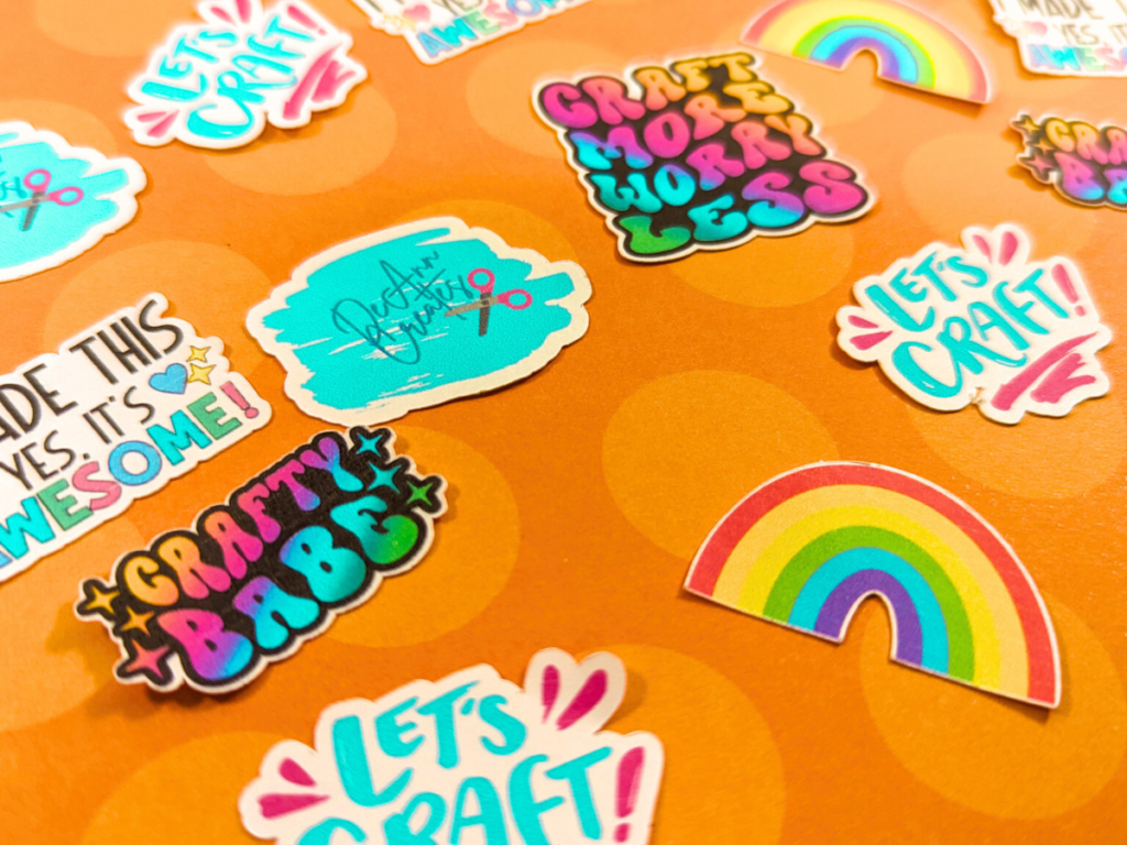 This image shows all of the DIY colorful stickers that were made with Cricut laying on an orange background with polka dots of a lighter orange shade. | How to Make Stickers with Cricut: Crafting Made Easy