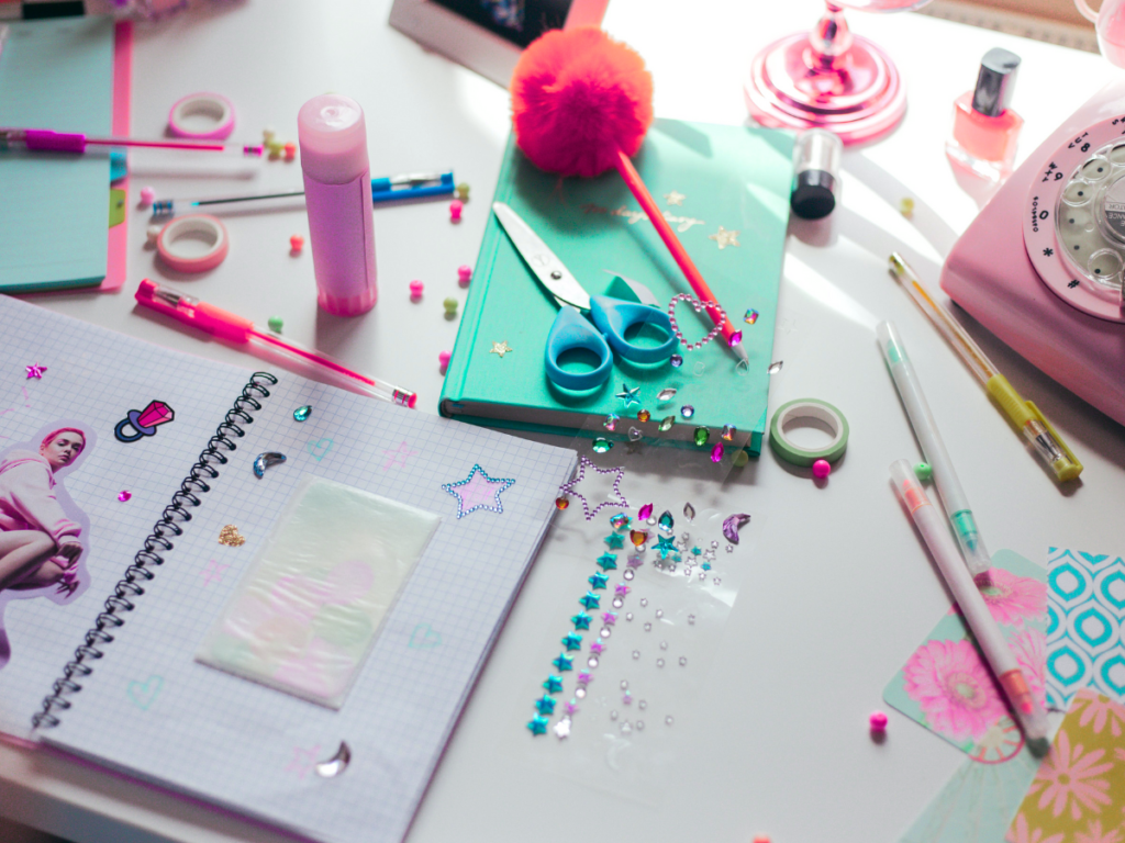 This image shows a open notebook laying on a table with colorful craft supplies scattered on top. | 3rd Anniversary of DeAnn Creates: 3 Years of Crafting Magic