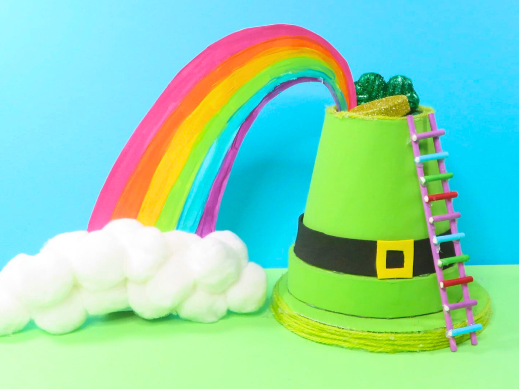 How to Make a Leprechaun Trap for St. Patrick's Day Fun | The completed leprechaun trap with a rainbow coming from the hat in front of a turquoise and green background