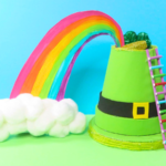 How to Make a Leprechaun Trap for St. Patrick's Day Fun | The completed leprechaun trap with a rainbow coming from the hat in front of a turquoise and green background