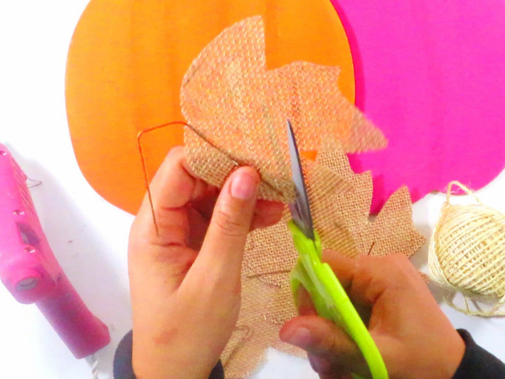 Cutting a large burlap leaf into a smaller leaf to better fit the craft project